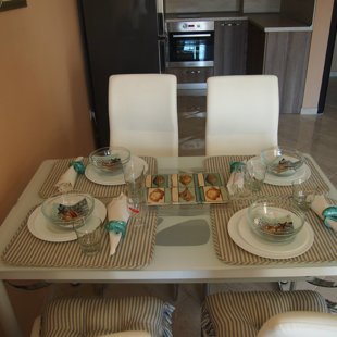 The glass top table and eco-leather chairs are comfortable and easy to maintain.