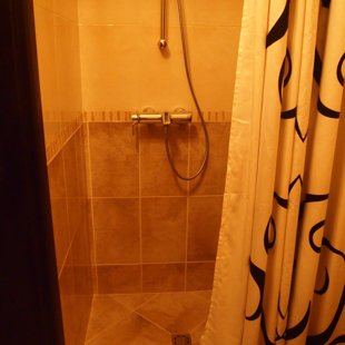 The bathroom is tiled floor-to-ceiling.