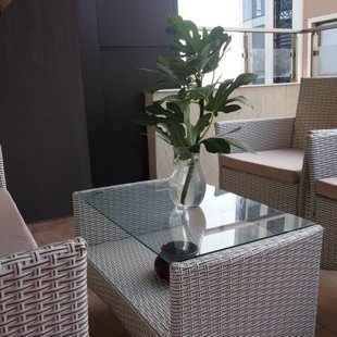The terrace has weather resistant rattan furniture.