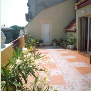 There are unbrellas, dryers and furniture on the north terrace in the summer.